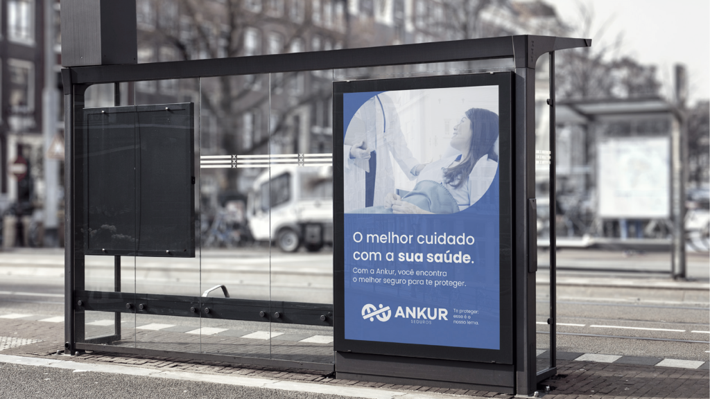 Aplicação da identidade visual da Ankur Seguros em um ponto de ônibus.